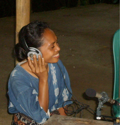 Singer listening to a recording of her own performance in Flores, Indonesia